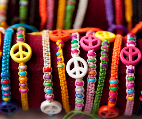 Several colorful, beaded bracelets with larger beads shaped like peace signs