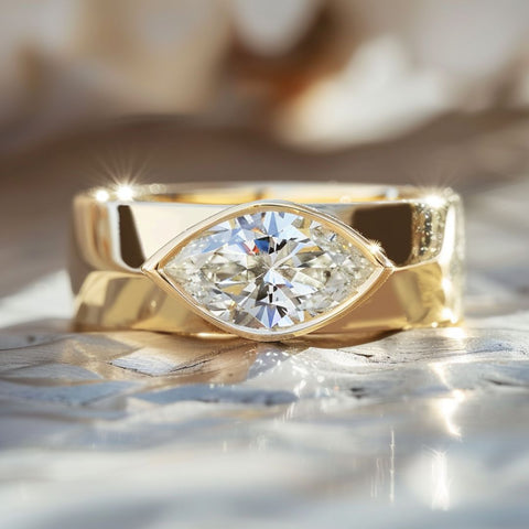 Alternative non-traditional Engagement Ring with gold cigar band and east west marquise diamond bezel set