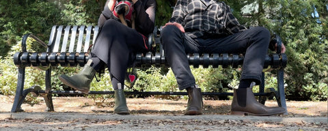 The Chelsea Boot Co Est. 1851 showing two people sitting on a bench. One woman and one man. Both wearing our Original Chelsea Boots.