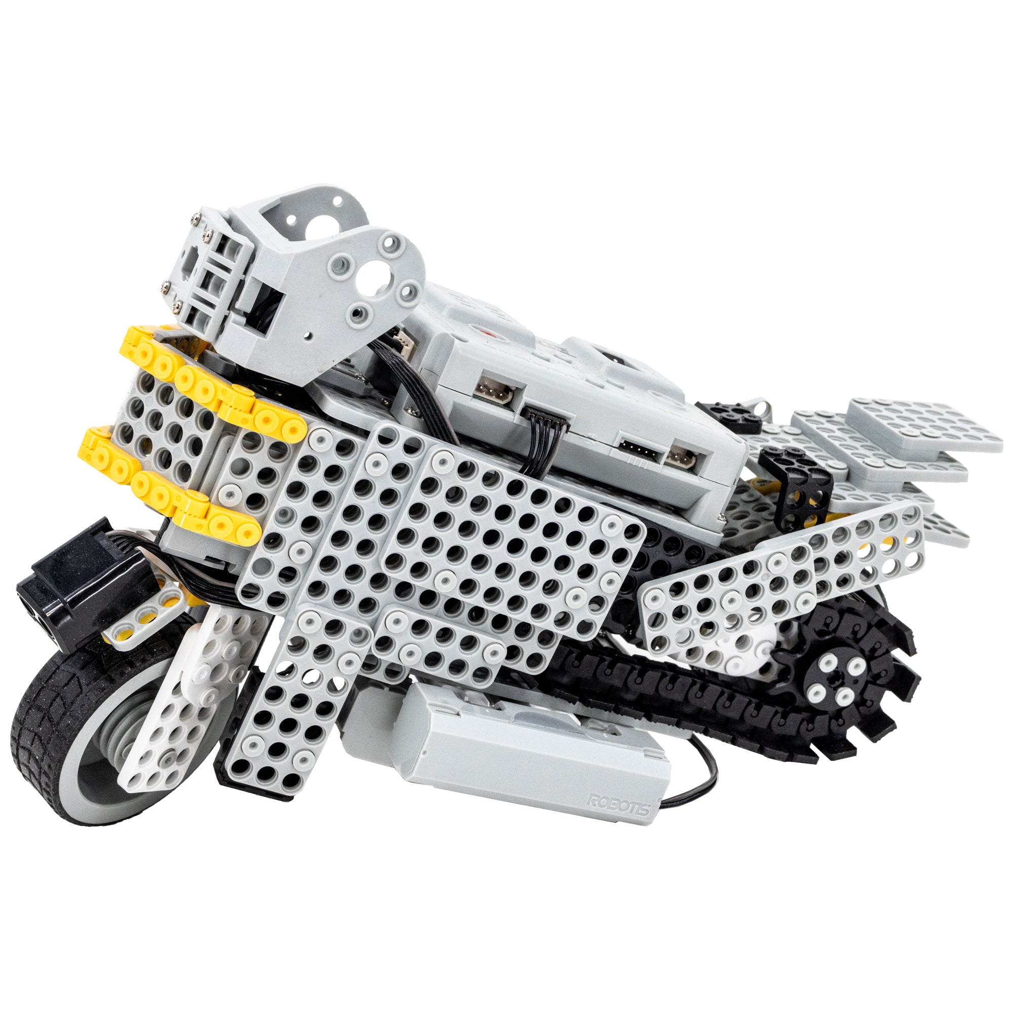 Robotis Bioloid Stem motorcycle structure. The pieces are light gray with holes throughout, like a grid. The back wheel is a black treadmill-type moving piece and the black front wheel has a sensor attached. There is a battery pack attached on the bottom and yellow trim on the font.