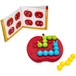 The Apple Twist Smart Game laid out with the green and blue caterpillar pieces in place on the board and the yellow caterpillar off to the right side, waiting to be put in place. In the upper-right is the instruction booklet open to one of the junior activities.