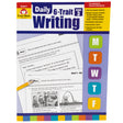 Daily 6 Trait Writing Grade 3 book. The background is white at the top, purple in the middle, and has a border at the bottom with many colored rectangles. There are colored squares off to the right with a letter in each square, including; M, T, W, T, F. There are 2 sample pages in the middle that show writing activities and illustrations.