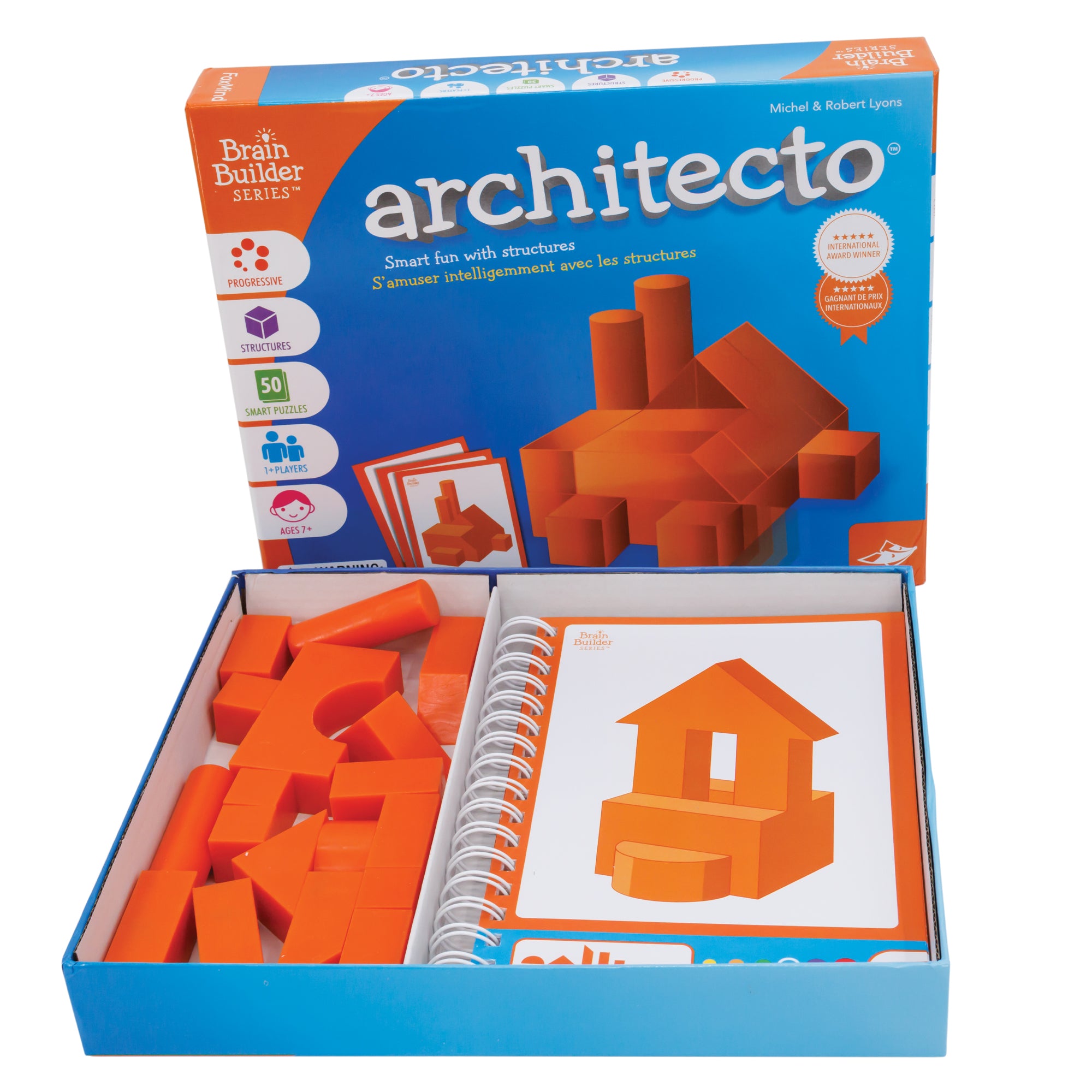 The Architecto game box open with the box bottom in front containing the spiral-bound activity book on the right showing a house structure. The game pieces on the left are orange triangles, cylinders, rectangles, squares, and an arch piece. The game box top in the back is mostly blue. The illustration in the middle is a structure created from the Architecto pieces. It looks like a factory with square pieces at the bottom, triangle pieces stacked on top, and 2 cylindrical pieces in the back left.