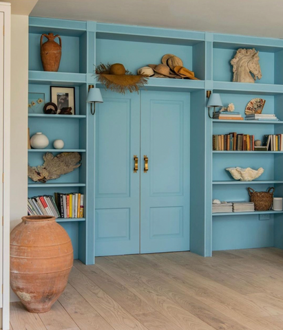 Blue bookcases stacked with curated treasures