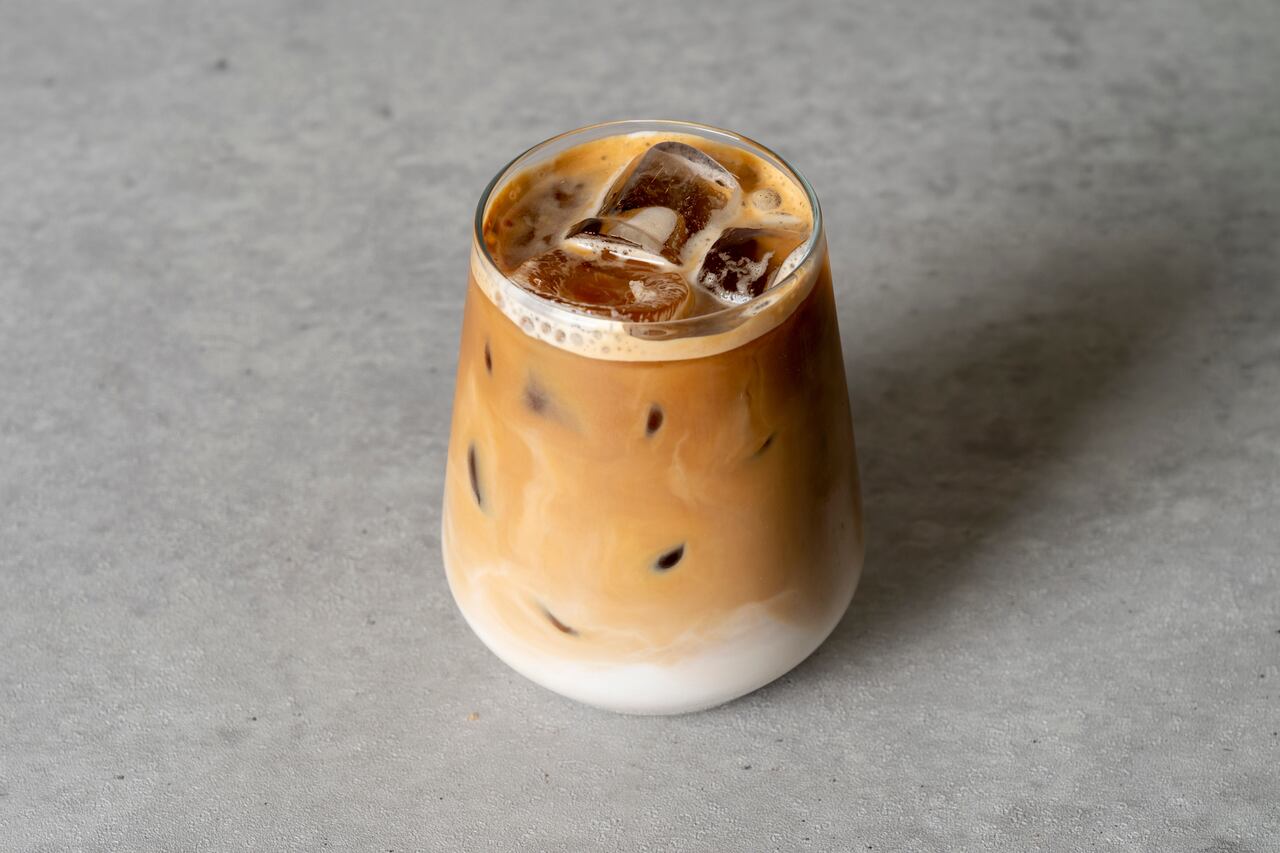 buzlu toffee nut latte kahvesinin olduğu bir bardak