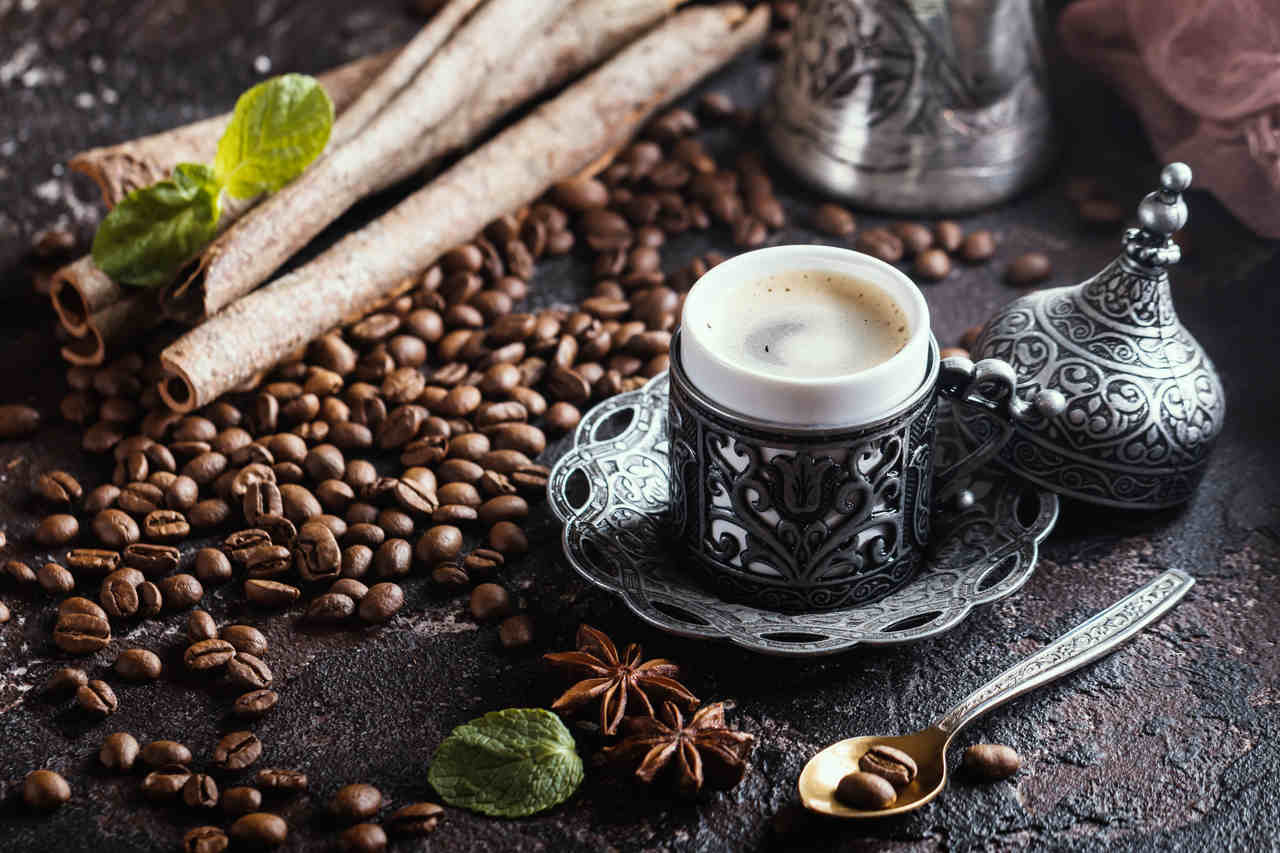 Kahve çekirdekleri üzerinde geleneksel metal fincanda Türk kahvesi