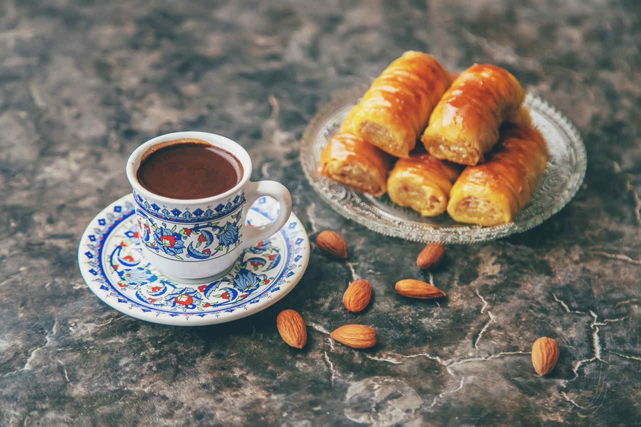 geleneksel türk kahvesi fincanında türk kahvesi ve yanında ikramlık baklava