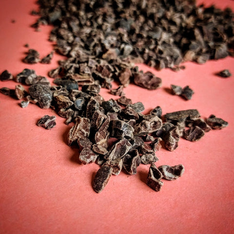 Cocoa nibs on red background