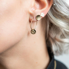 Model wearing 14K gold lotus flower charm hoop earrings