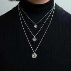 Closeup of model wearing Reflections Wave Charm Necklaces