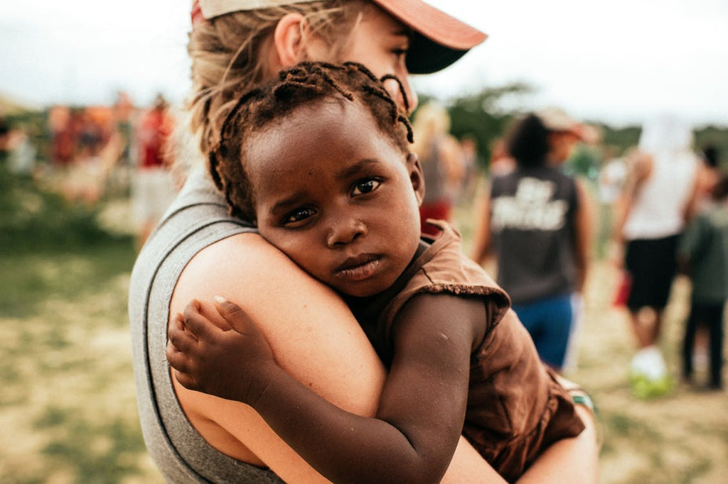 Blonde Woman Holding African Orphan