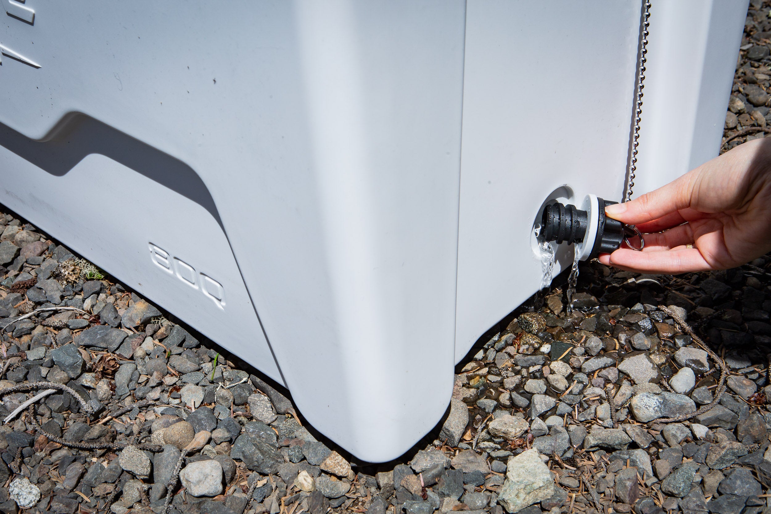 opening the drain plug on a heavy duty rotomolded camping cooler