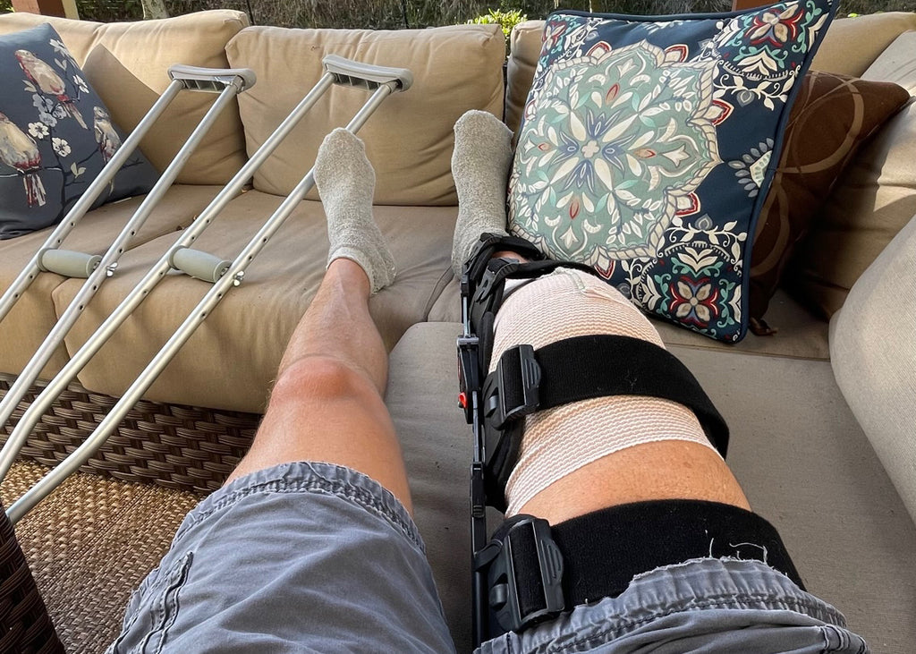 Injured Knee in a Brace on a Couch with Crutches