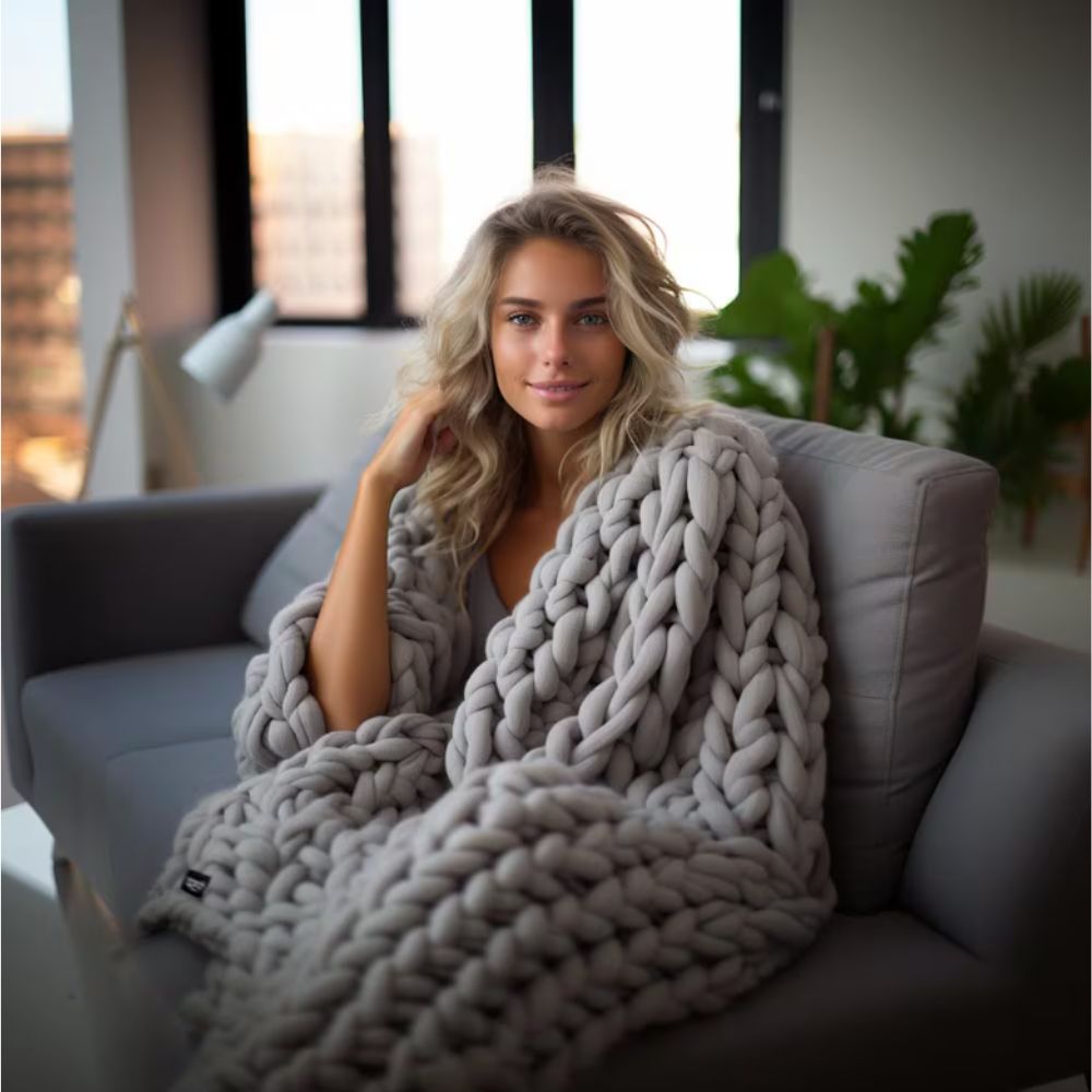 A lady covered in Chunky Knit Weighted Blanket