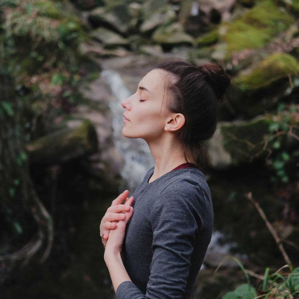 Woman in nature doing breathing exercises
