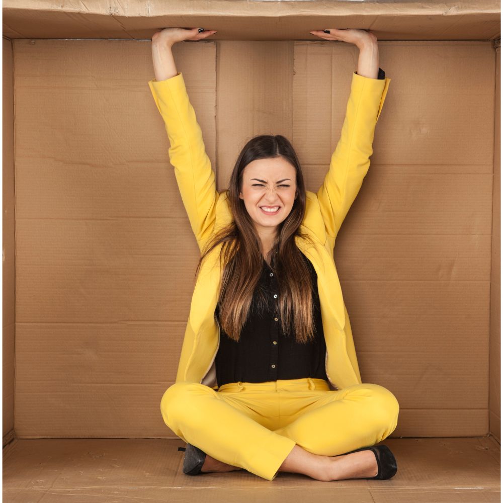 Woman sitting in a box trying to get out