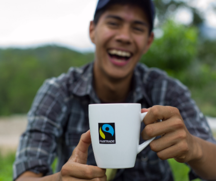 Man smiling and drinking from Fairtrade coffee mug 