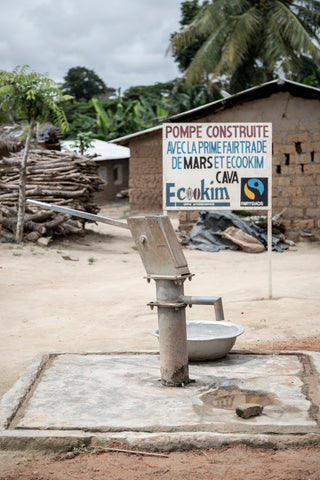 Water pump with sign behind for Fairtrade Foundation