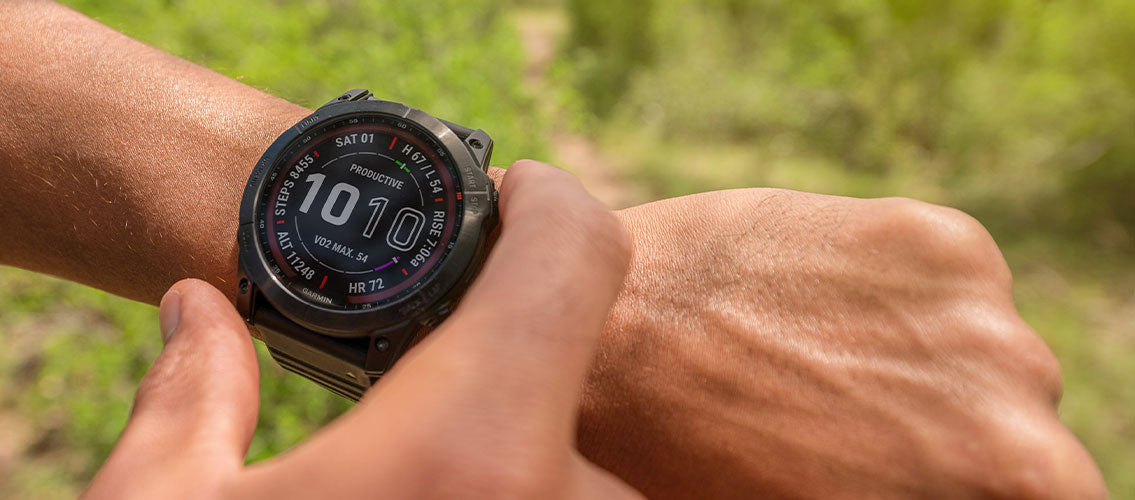 Man outdoors checing Garmin fenix 7 GPS watch