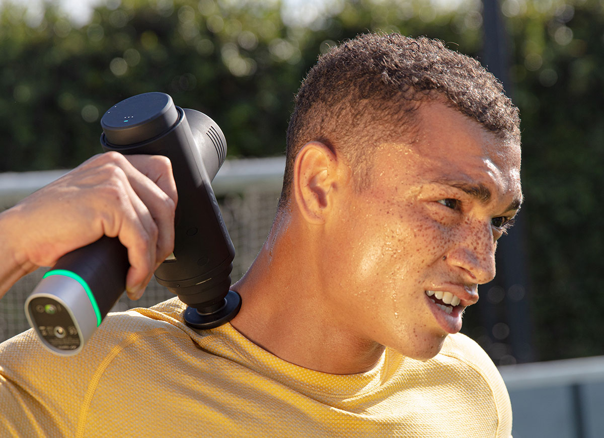 Man using Hyperice Hypervolt Series massage gun on shoulder