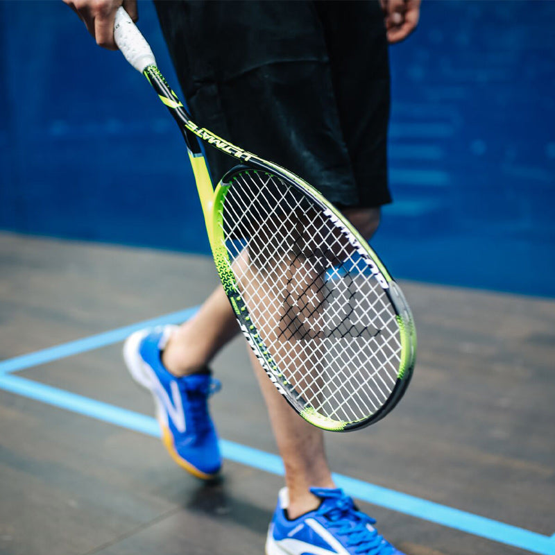 Close-up of man on indoor court holding squash racquet
