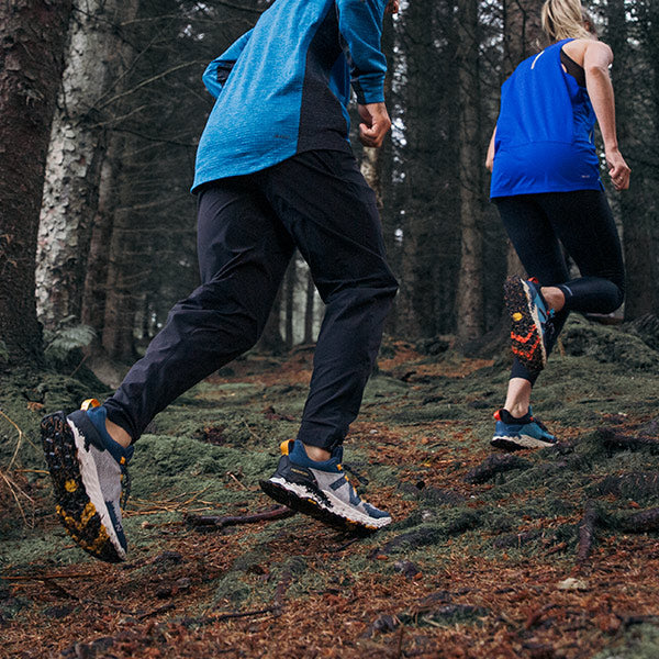 Man and woman running on trail in New Balance Trail Running Shoes