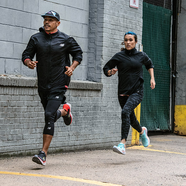 Man and woman in city running in New Balance Road Running Shoes