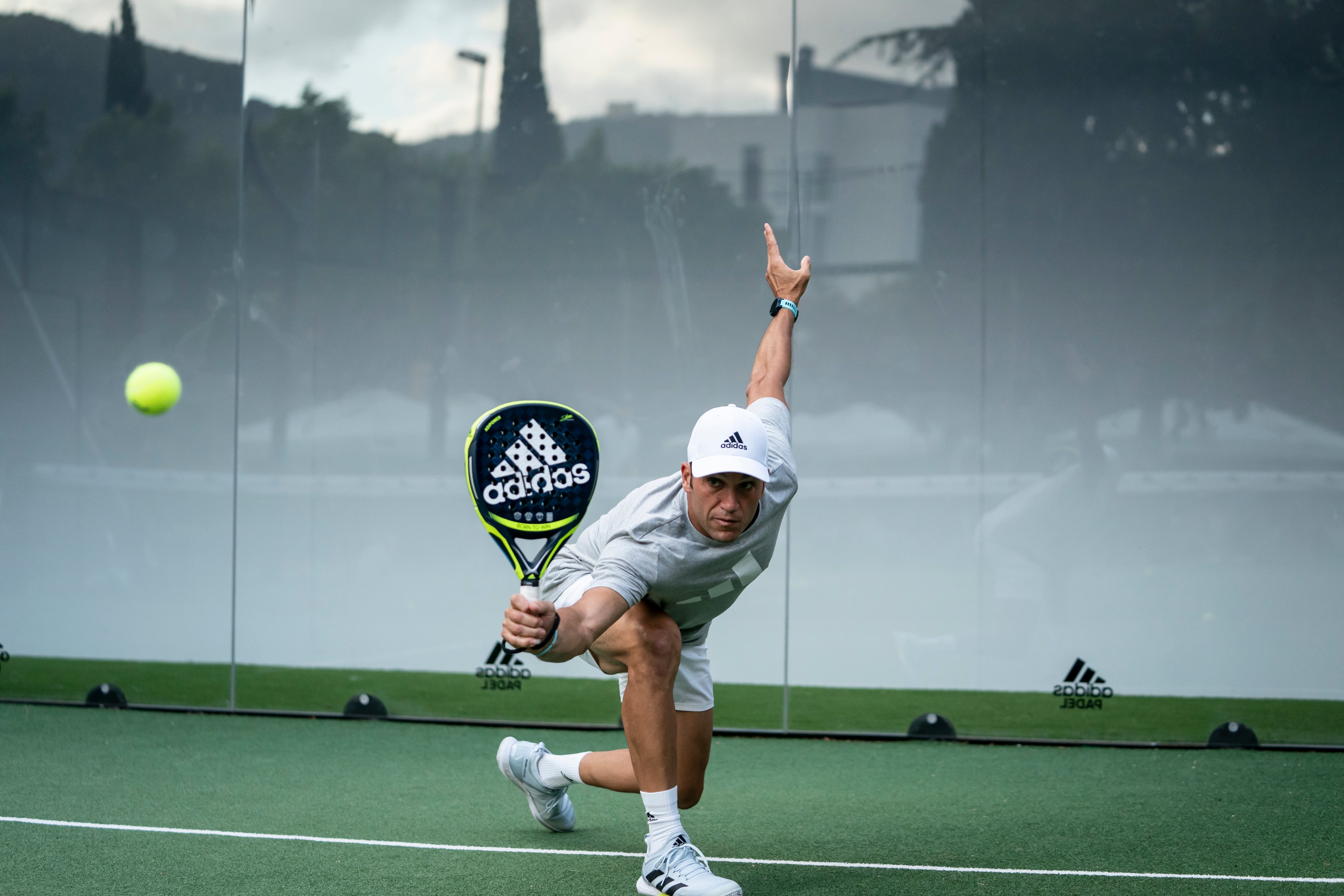 Seba Nerone reaching with his padel racquet after hitting the ball