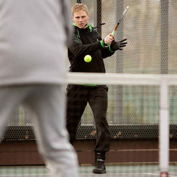 Man in mid-motion hitting plaform tennis ball on court