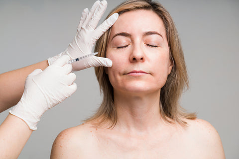 Medical esthetician performing service on woman's face