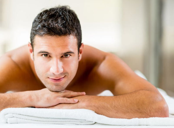 smiling man facedown on waxing table