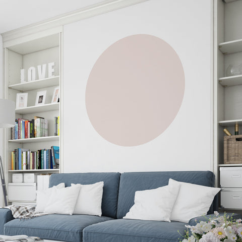 Blue sofa with a large dusky pink colour block circle above on a white wall.