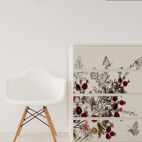 Ikea Malm drawers with Nutmeg stickers over the drawers next to a white chair