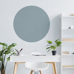 Large blue/grey circle wall sticker above a white desk with plants