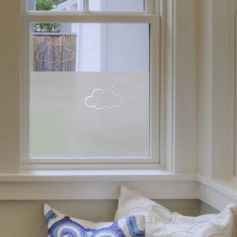 A window partially covered with frosted window film with a cloud design