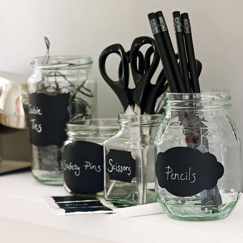 Jam jars holding stationery, labelled with black chalk board stickers