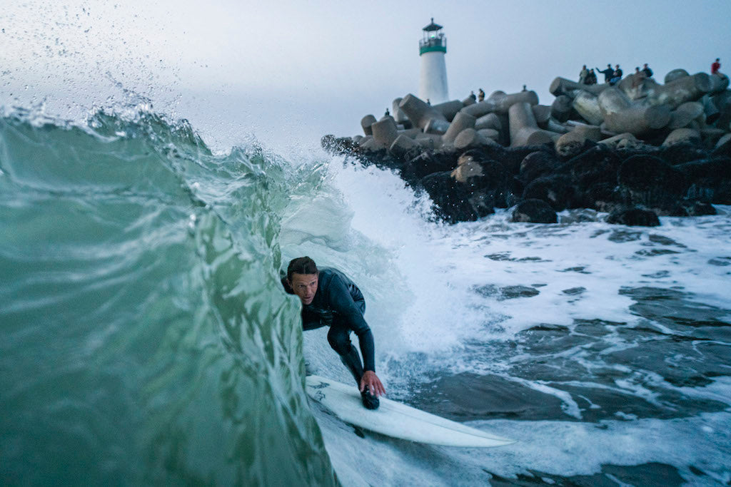 Guy catching a break with lighthouse in the background 