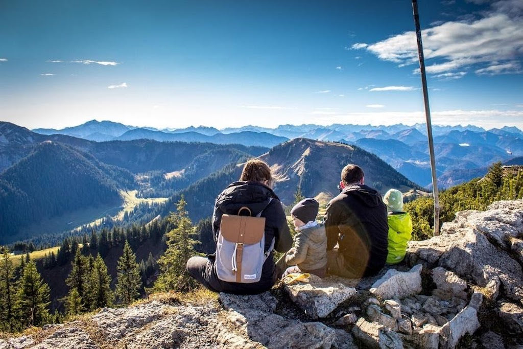 Family sitting looking over a mountain range 