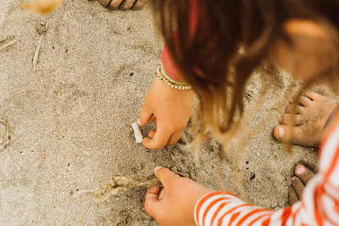 Children collecting plastic debris from sand