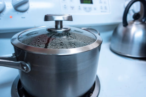 Silver pot with lid on stove top