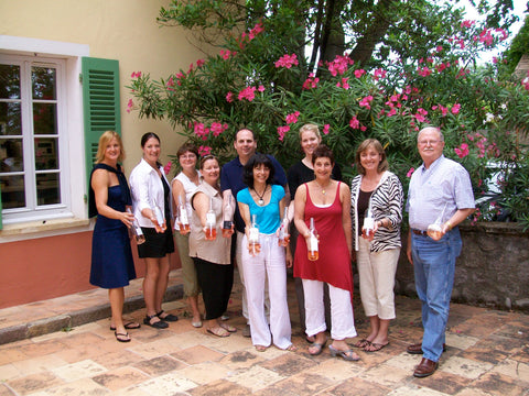 A group of people studying at Provence Association of Winemakers and Viticulture holding wine bottles for the HaloVino wine blog.