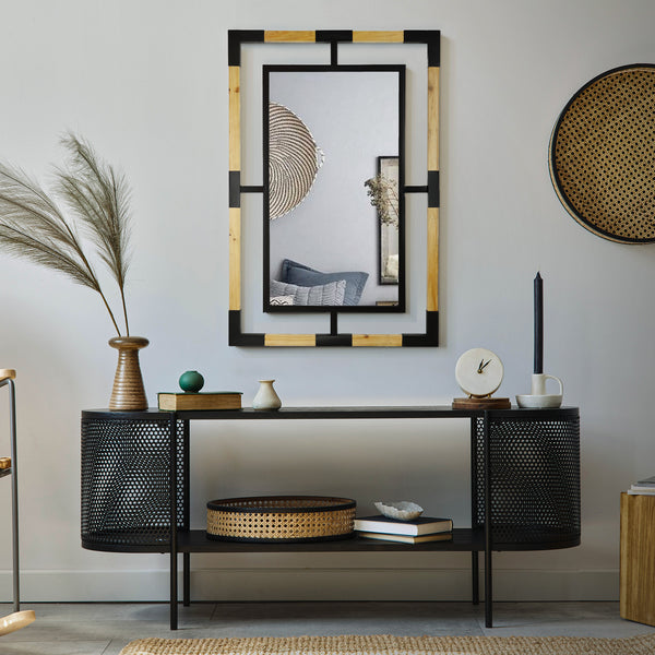 Headwest Mirror's Wood And Metal Framed Floating Accent Wall Mirror hanging above a black metal shelving unit with other decor such as, an area rug, book, clock, candle and vase. in a living room