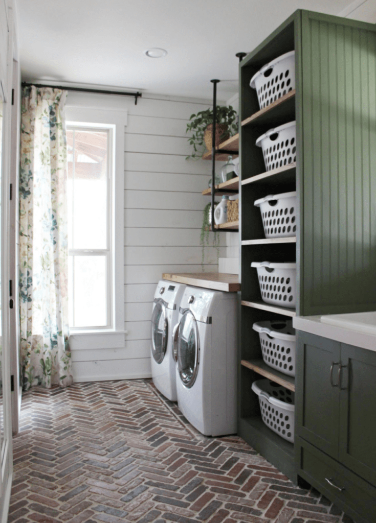 Laundry room with brick chevron floors, built-in shelving, floating shelves, and a window