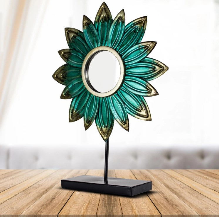 Turquoise Metal Flower Sculpture sitting on a wood table near a window. 