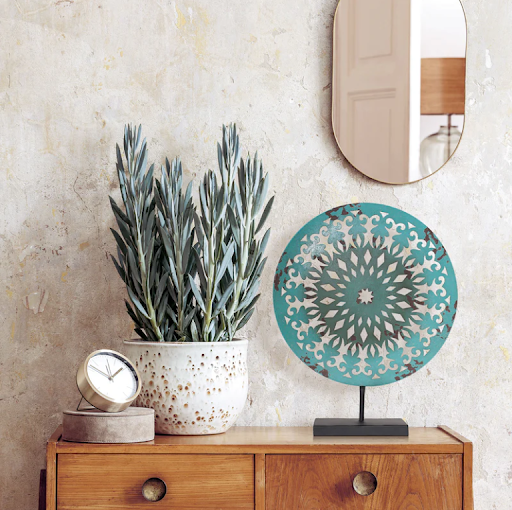 American Art Decor's Turquoise Rustic Medallion on a wood table.