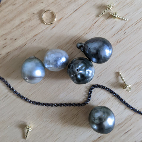 Tahitian baroque pearls that range from silver to black, with gold findings and black chain