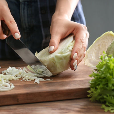 woman cutting fresh cabbage