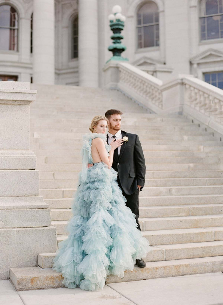 Woman in blue gown and man stand on the wisconsin capitol stairs