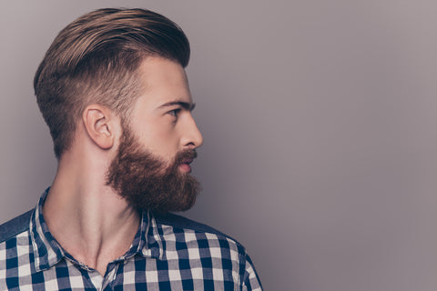 Side view portrait of handsome young man with luxurious, healthy beard - looking away