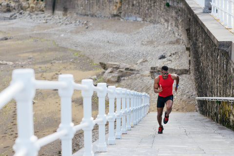 The Best Sleep Hacks for Peak Athletic Performance. Fit young man training by running up stairs